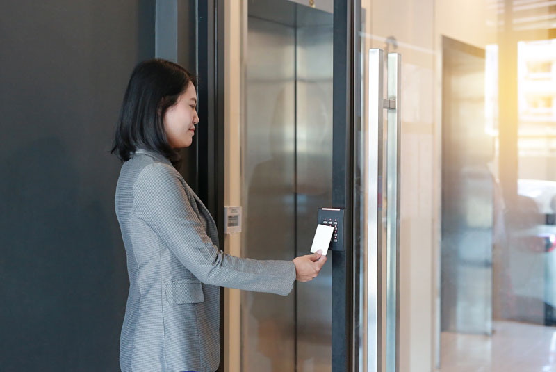 Woman using access control to building